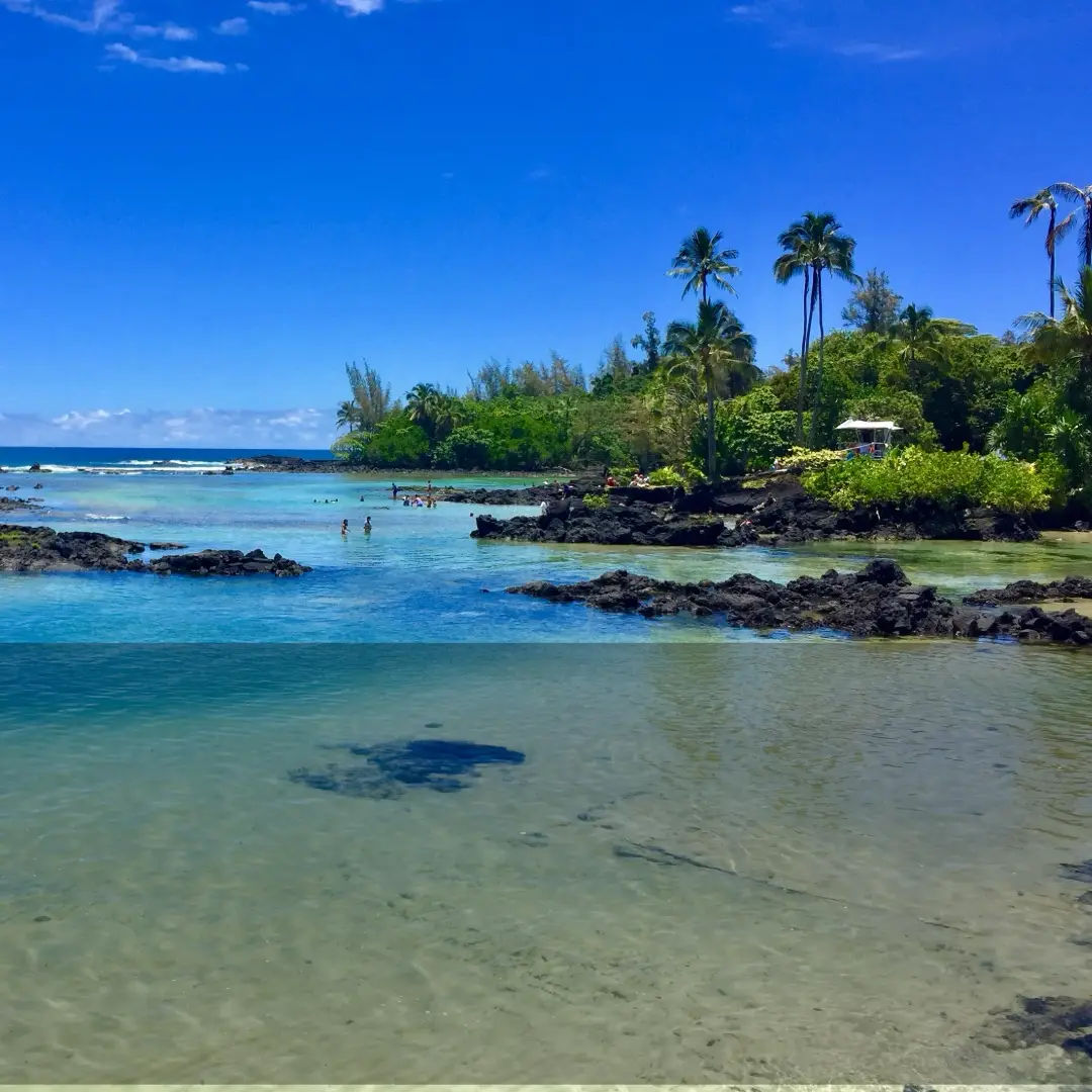 Carlsmith Beach Park lagoons on the Big Island, featuring protected lava rock tide pools, clear blue water, and tropical shoreline.