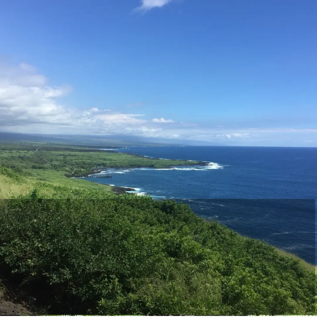 Wide coastal view of the Kaʻū coastline on the Big Island of Hawaiʻi, with green cliffs meeting the Pacific Ocean.