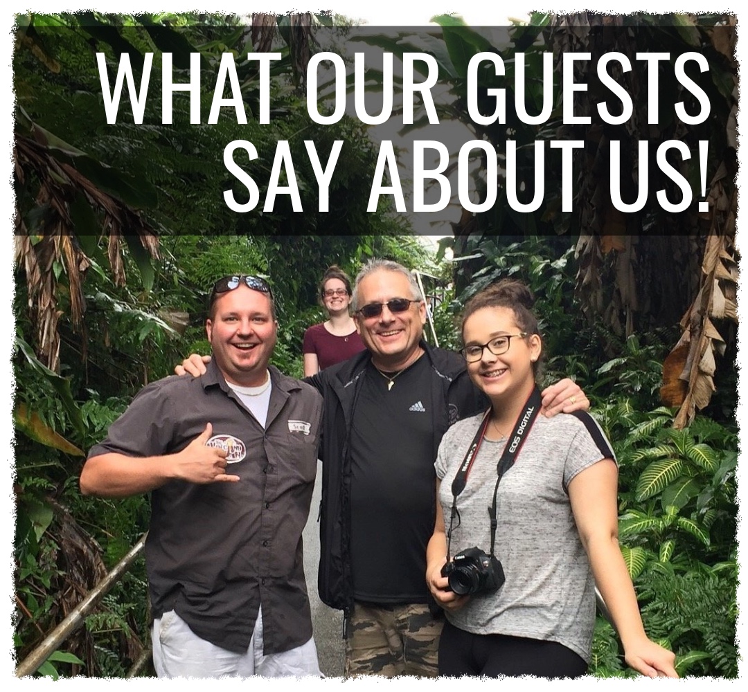 Happy guests on a private Big Island rainforest tour with The Volcano Van, smiling with their guide among lush tropical greenery